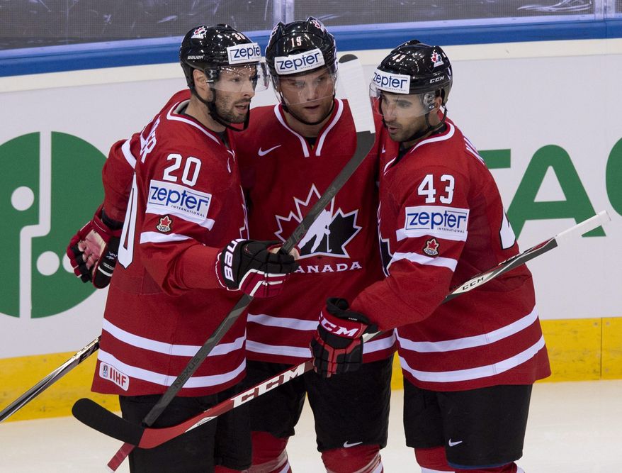 Team Canada&#x27;s Cody Hodgson, center, is congratulated by teammates Troy Brouwer, left, and Nazem Kadri, after he scored the first goal against Denmark during first period action at the IIHF World Hockey Championship in Minsk, Belarus, Thursday, May 15, 2014. (AP Photo/The Canadian Press, Jacques Boissinot)