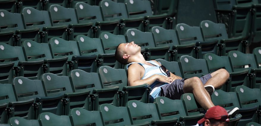 Stan Lute leans back in a seat along the left field line and in full sun as he watches his first Seattle Mariners baseball game Wednesday, May 14, 2014, in Seattle. A couple more sunny days with above-normal temperatures in the 70s and 80s are forecast for the Northwest, but the summer preview isn't expected to last through the weekend. (AP Photo)