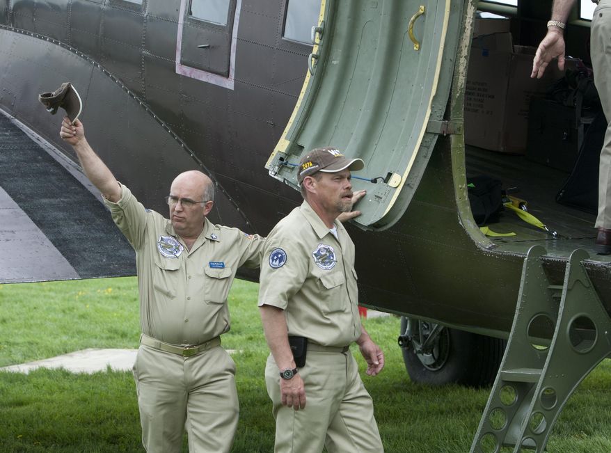 Chief of maintenance Craig Wadsworth, left, waves to the crowd next to crew chief Mike Lindsay before boarding the C-47 'Whiskey 7' for the "Return to Normandy" project being carried out by the Geneseo National Warplane Museum in Geneseo, N.Y., on Thursday May 15 2014.  The Douglas C-47, a World War II transport plane that dropped American paratroopers on Normandy departed from Geneseo, in New York Thursday for a D-Day 70th anniversary commemoration in France. (AP Photo/Democrat & Chronicle, Carlos Ortiz)  MAGS OUT; NO SALES