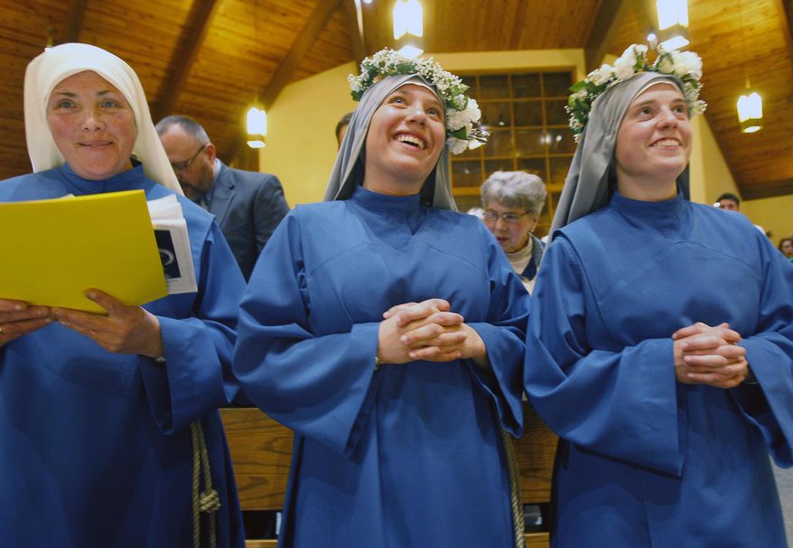 Mother Mary Catherine, left, Sister Maria Lucia Stella Maris, center, and Sister Marie Bernadette of the Sacred Heart, celebrate at the end of the Mass at St. Pius X Roman Catholic church that established the Missionaries of the Word on May 1, 2014 in Appleton, Wis. The three women are the founding members of the new religious community who will teach young people about Jesus. (AP Photo/The Post-Crescent, Wm. Glasheen)