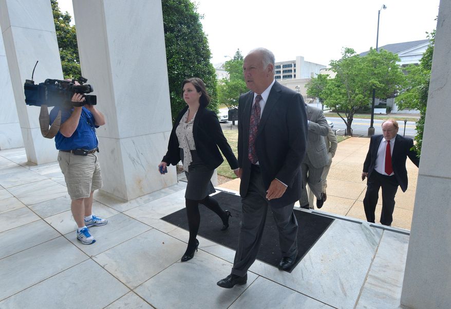 Former University of Georgia football coach Jim Donnan, right, heads into the Federal Courthouse on Wednesday, May 14, 2014, Athens, Ga. Prosecutors say the 69-year-old and another man ran a fraudulent investment scheme from September 2007 to December 2010 through GLC Limited, a West Virginia-based company dealing in wholesale and closeout merchandise. Prosecutors say the pair promised high rates of return but paid investors with other investor money. (AP Photo/Athens Banner-Herald, Richard Hamm) MAGS OUT; MANDATORY CREDIT