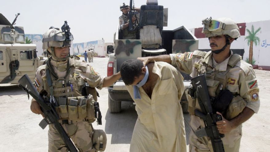 ** FILE ** Iraqi army soldiers bring in a blindfolded and handcuffed suspected Al Qaeda member to detention centers in an Iraqi army base in Baghdad, Iraq, July 25, 2012. (Associated Press)