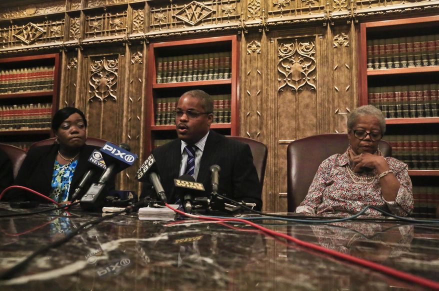 Attorney Derek Sells, center, sets between between Alma Murdough, right, and Cheryl Warner, left, the mother and sister of former Marine Jerome Murdough, during a news conference on Friday May 16, 2014 in New York. Sells plans to file a wrongful death lawsuit against the city on behalf of Alma Murdough for the death of her son, who was found dead in a 100 degree cell on Rikers Island. (AP Photo/Bebeto Matthews)
