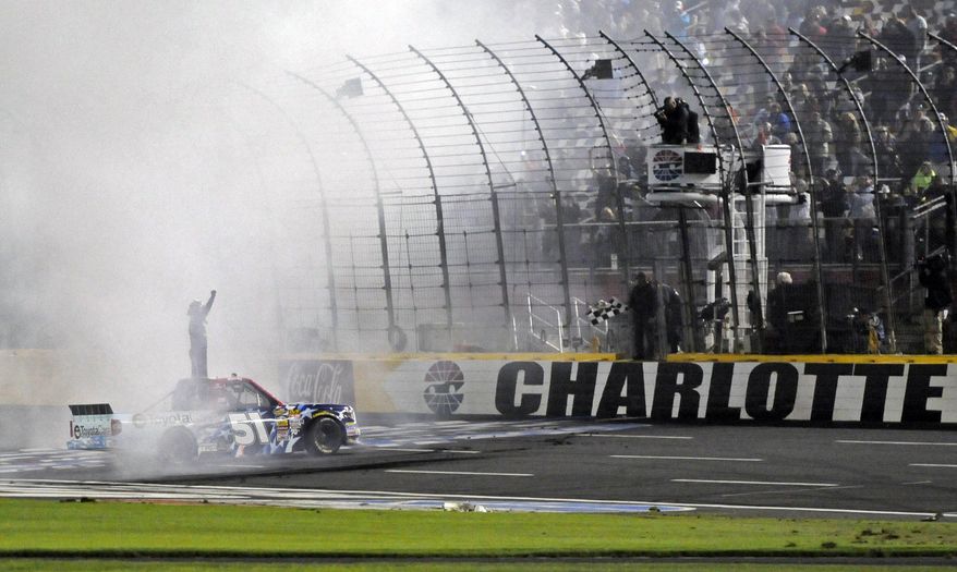 Kyle Busch celebrates after winning the NASCAR Trucks series auto race at Charlotte Motor Speedway in Concord, N.C., Friday, May 16, 2014. (AP Photo/Mike McCarn)