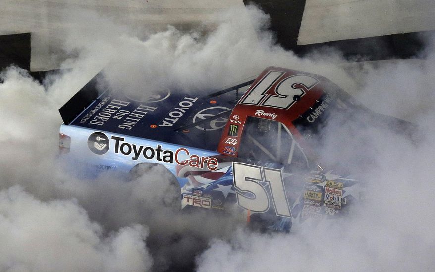Kyle Busch does a burnout after winning the NASCAR Truck series auto race in Concord, N.C., Friday, May 16, 2014. (AP Photo/Gerry Broome)