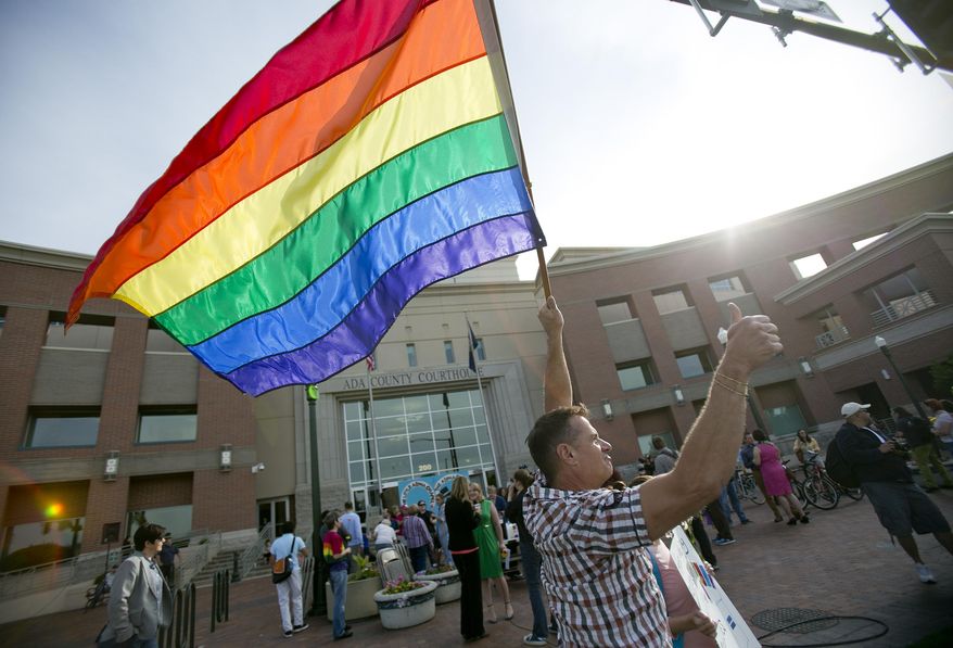 Carmine Caruso holds a rainbow flag during a rally in supports of same sex marriage in front of the Ada County courthouse in Boise, Idaho, on Friday, May 16, 2014. Idaho's gay marriage ban was overturned Tuesday when U.S. District Judge Candy Dale said the law unconstitutionally denied gay and lesbian residents their fundamental right to marry. On May 15, 2014, a three-judge panel of the 9th U.S. Circuit Court of Appeals issued a temporary stay while it considers whether a longer stay is needed. (AP Photo/The Idaho Statesman, Kyle Green) LOCAL TV OUT