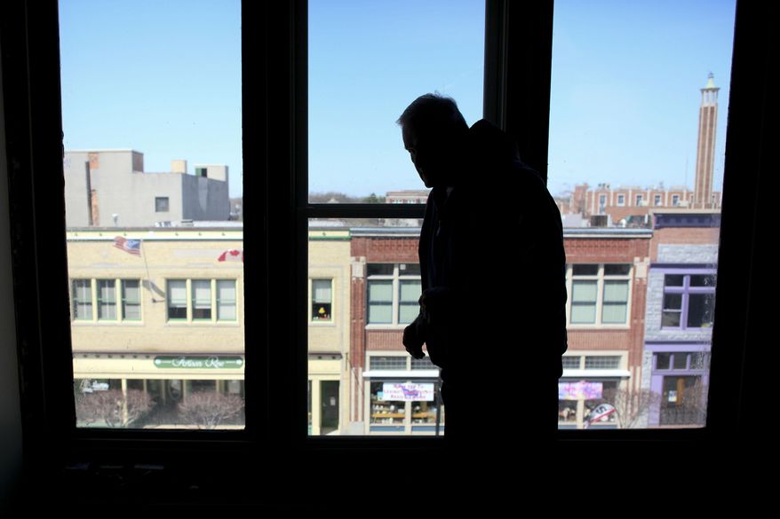 ADVANCE FOR RELEASE SUNDAY, MAY 18, 2014, AT 12:01 A.M. EDT - In this May 6, 2014 photo, Dave Witt looks out a window facing Huron Avenue at the lofts above Ben's Fine Furniture in downtown Port Huron, Mich. The Witts' Port Huron loft total will reach 43 upon completion, he told the Times Herald of Port Huron. The Witts have completed six other loft renovation projects, the majority in downtown Port Huron, and including the construction of the Arashi Lofts just north of the Military Street Bridge. (AP Photo/The Port Huron Times Herald, Jeffrey Smith) NO SALES