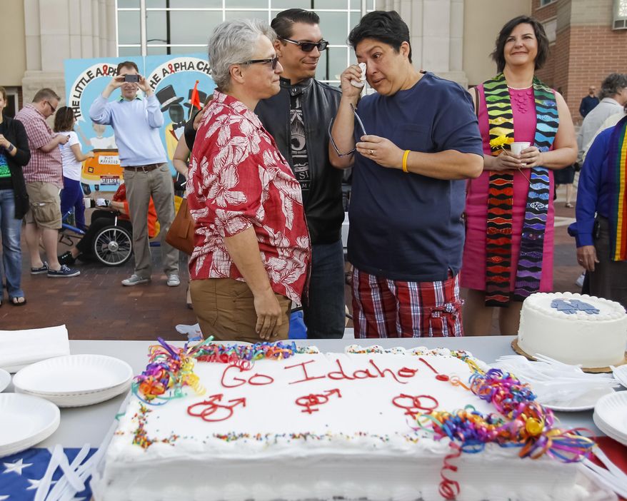 CORRECTS NAME FROM JUDY MAY-CHANG TO JODY MAY-CHANG Maria May-Chang, right, wipes away a tear after having a piece of cake with her wife Judy May-Chang, left, and their son Cody at the Ada County Courthouse in Boise, Idaho, on Friday, May 16, 2014. Maria and Jody were married last year in Washington state and were hoping to get a license in Idaho after a federal judge overturned Idaho's gay marriage ban on Monday, ordering the state to issue marriage licenses to same sex couples beginning Friday morning. On May 15, 2014, the 9th U.S. Circuit Court of Appeals gave Idaho a temporary stay from that order. (AP Photo/Otto Kitsinger)