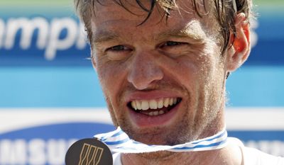 FILE -  In this Saturday, Sept. 3, 2011 file photo, British rower Alan Campbell displays his bronze medal on the podium after the Men's Single Sculls Final event at the World Rowing Championships in Bled, Slovenia. Campbell, whose abscessed lower-left wisdom tooth threatened to keep him from the 2008 Beijing Olympics, is certain that taking better care of his teeth has helped him row faster.  (AP Photo/Filip Horvat, File)