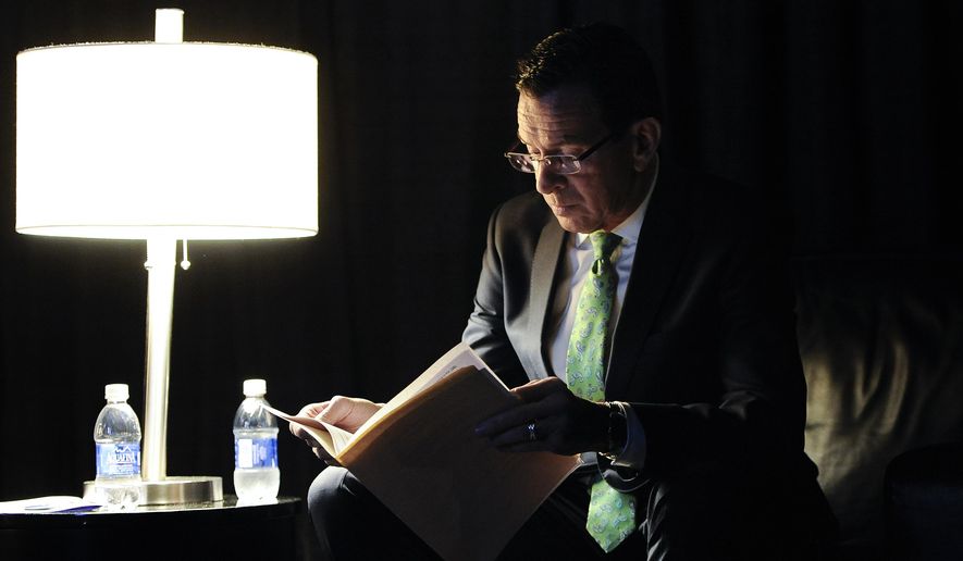 Gov. Dannel P. Malloy reads over his speech in a private area backstage while waiting as delegates nominate him as the Democratic candidate for governor at the Connecticut Democratic Convention, Friday, May 16, 2014, in Hartford, Conn. (AP Photo/Jessica Hill)