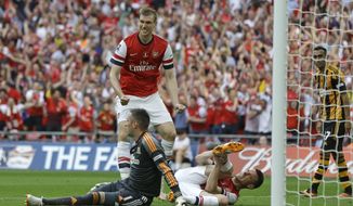 Arsenal&#x27;s Laurent Koscielny, bottom right,  holds his leg after taking a knock when scoring his sides second goal during the English FA Cup final soccer match between Arsenal and Hull City at Wembley Stadium in London, Saturday, May 17, 2014. (AP Photo/Kirsty Wigglesworth)