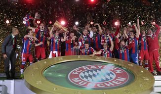 The team of German soccer club Bayern Munich celebrates with the trophy after winning the German Soccer Cup Final between FC Bayern Munich and Borussia Dortmund at the Olympic Stadium Berlin, Germany, Saturday, May 17, 2014. (AP Photo/Markus Schreiber)