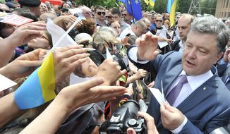 Ukrainian presidential candidate Petro Poroshenko, right, is welcomed by his supporters during a rally  in Kruvuy Rig, Ukraine, Saturday, May 17, 2014. A Presidential vote in Ukraine is scheduled for May 25. (AP Photo/Mykola Lazarenko, Pool)