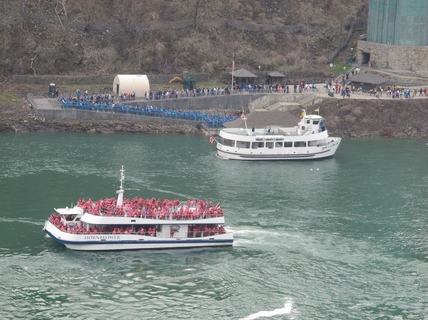 This May 15, 2014, photo shows a Hornblower Niagara Cruises Catamaran, foreground, and a Maid of the Mist boat, background, in the Niagara Gorge below Niagara Falls. The Maid of the Mist Steamboat Co. continues to launch from the American shore but lost its Canadian contract to rival Hornblower Niagara Cruises.(AP Photo/Carolyn Thompson)