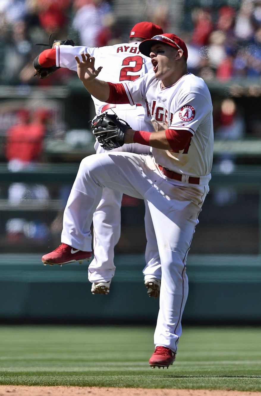Los Angeles Angels’ Mike Trout, front, jumps up with Erick Aybar, back, in celebration after a baseball game against the Tampa Bay Rays in Anaheim, Calif., Sunday, May 18, 2014. The Los Angeles Angels won 6-2. (AP Photo/Kelvin Kuo)