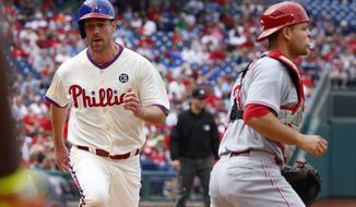 Philadelphia Phillies&#39; Cliff Lee, left, comes in to score on a ground out by Chase Utley as Cincinnati Reds catcher Devin Mesoraco, right, looks for the ball during the fifth inning of a baseball game, Sunday, May 18, 2014, in Philadelphia. (AP Photo/Chris Szagola)