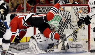 Chicago Blackhawks&#39; Jonathan Toews (19)  flies over Los Angeles Kings goalie Jonathan Quick (32) during the second period in Game 1 of the Western Conference finals in the NHL hockey Stanley Cup playoffs in Chicago on Sunday, May 18, 2014. The Blackhawks won 3-1. (AP Photo/Nam Y. Huh)