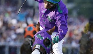 Jockey Victor Espinoza celebrates aboard California Chrome after winning the 139th Preakness Stakes horse race at Pimlico Race Course, Saturday, May 17, 2014, in Baltimore. (AP Photo/Matt Slocum)