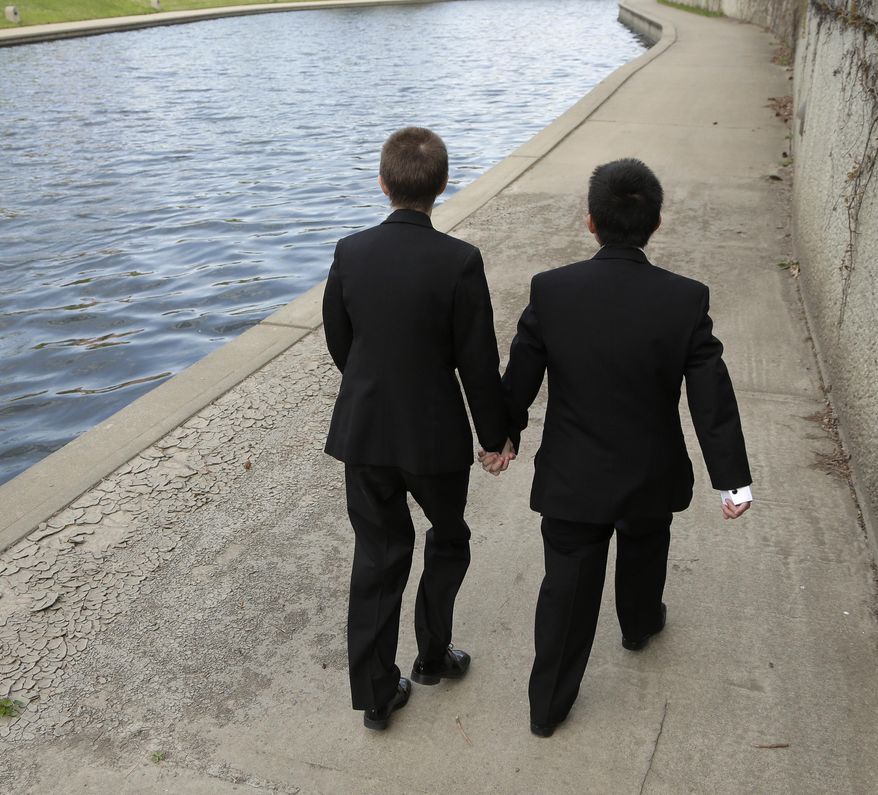 In this April 23, 2014 photo, transgender high school students Isaac Barnett, right, and his prom date, identified only by his first name Jasen, walk along a creek in the Country Club Plaza shopping district after picking up their tuxedos for prom in Kansas City, Mo. The seniors, both born as females, are open about their transgender status in their schools and say friends, teachers and administrators have been much more supportive than they expected. (AP Photo/Charlie Riedel)