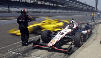 Will Power, (12) of Australia, waits as teammate Helio Castroneves, of Brazil, pulls out around him as they leave the pit area during practice for the Indianapolis 500 IndyCar auto race at the Indianapolis Motor Speedway in Indianapolis, Monday, May 19, 2014. (AP Photo/Michael Conroy