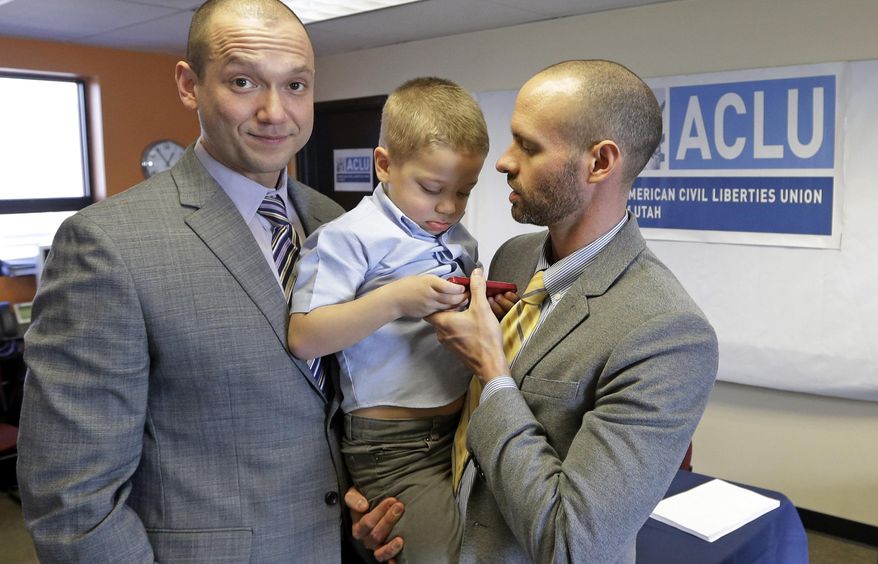 FILE - In this Jan. 21, 2014, file photo, plaintiffs Matthew Barraza, left, looks on as his husband Tony Milner, right, holds their son Jesse, 4, following a news conference in Salt Lake City. A federal judge Monday, May 19, 2014, ordered Utah officials to recognize more than 1,000 same-sex marriages that took place in the state before the U.S. Supreme Court issued an emergency stay. The American Civil Liberties Union filed the lawsuit in January on behalf of four couples who said the state's decision to freeze benefits for same-sex couples violated their right. Barraza and Milner were one of the four couples who sued. Only Barraza is legally recognized as a parent of Jesse. (AP Photo/Rick Bowmer, File)