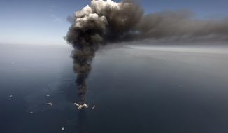In this Wednesday, April 21, 2010, file photo, oil can be seen in the Gulf of Mexico, more than 50 miles southeast of Venice on Louisiana&#39;s tip, as a large plume of smoke rises from fires on BP&#39;s Deepwater Horizon offshore oil rig. (AP Photo/Gerald Herbert, File)