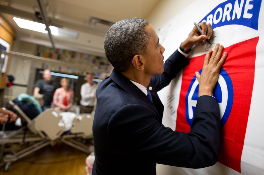 President Barack Obama autographs a banner while visiting a wounded service member at Walter Reed National Military Medical Center in Bethesda, Md., June 28, 2012. (Official White House Photo by Pete Souza)

This official White House photograph is being made available only for publication by news organizations and/or for personal use printing by the subject(s) of the photograph. The photograph may not be manipulated in any way and may not be used in commercial or political materials, advertisements, emails, products, promotions that in any way suggests approval or endorsement of the President, the First Family, or the White House.