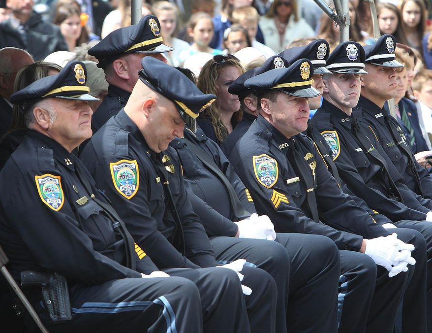 Police officers from the Brentwood, N.H. police department listen Monday May 19, 2014 in Concord, N.H. during the annual ceremony to honor Law Enforcement officers who died in the line of duty. Brentwood officer Stephen Arkell's name will be added to the list. Last Monday, Arkell responded to a domestic dispute and when he entered the house, he was immediately shot to death by the homeowner's son. (AP Photo/Jim Cole)