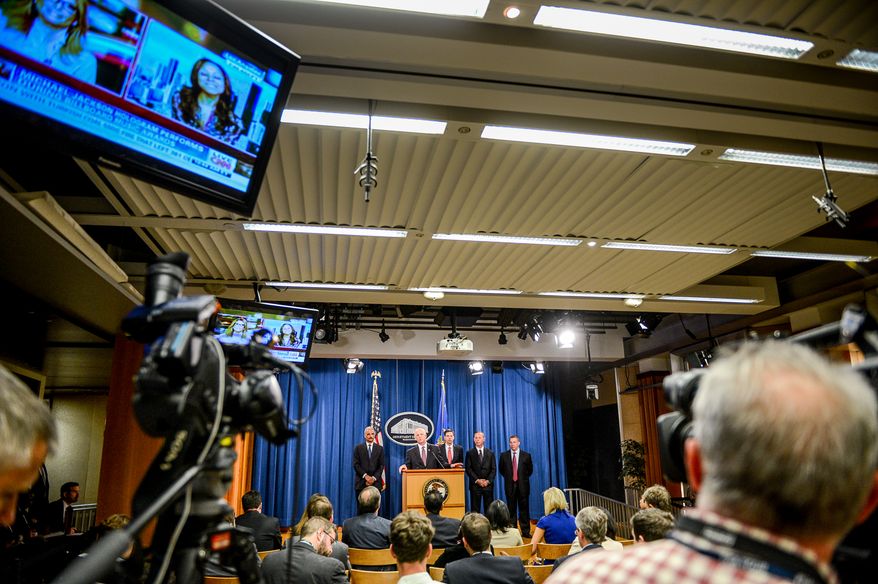 Attourney General Eric Holder announces a criminal indictment against five Chinese military hackers for cyber espionage at a press conference at the Department of Justice, Washington, D.C., Monday, May 19, 2014. The five hackers are identified as Wen Xinyu, Wang Dong, Sun Kailiang, Huang Zhenyu, and Gu Chunhui and are charged with targeting U.S. corporations and labor organizations for commercial advantage. (Andrew Harnik/The Washington Times)