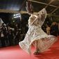 An unidentified guest walks on the red carpet as she arrives for the screening of Coming Home (Gu Lai) at the 67th international film festival, Cannes, southern France, Tuesday, May 20, 2014. (AP Photo/Thibault Camus)