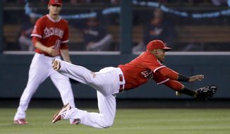 Los Angeles Angels shortstop Erick Aybar, right, can&#39;t get a glove on a single by Houston Astros&#39; Chris Carter as Grant Green looks on during the third inning of a baseball game in Anaheim, Calif., Monday, May 19, 2014. (AP Photo/Chris Carlson)