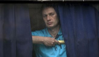 A man looks out of the back window of a bus in Donetsk, Ukraine, Monday May 19, 2014. Ukraine will hold presidential elections on May 25. (AP Photo/Vadim Ghirda)