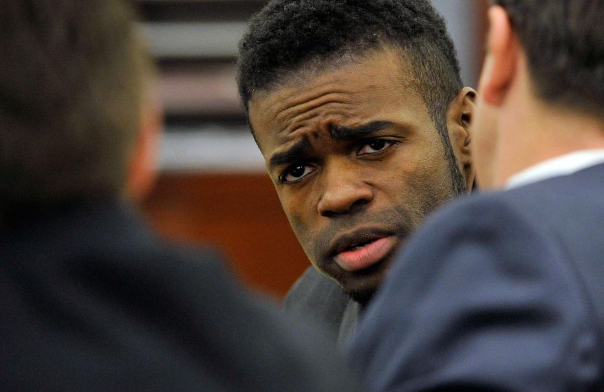 Jason Omar Griffith, center, looks to his defense attorneys, Abel Yanez, left, and Jeff Banks, in court during his murder trial the Regional Justice Center on Monday, May 19, 2014, in Las Vegas. Griffith is accused of killing Luxor "Fantasy" dancer Deborah Flores Narvaez in December 2010. (AP Photo/Las Vegas Review-Journal, David Becker)