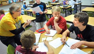 File -- In this Oct. 18, 2013 file photo Chippewa Falls, Wis., Middle School Teacher Melissa Rasmus, left, works with 8-grade students, from top: Taylor Detlaff, 13; Mitchell Haglund, 14; Logan Kurtenbach,14 and Chase Bergeron, 14, during a math class at the Wisconsin school. Officials said Tuesday, May 20, 2014 that more 2,800 students have applied to receive a taxpayer-funded voucher to attend private and religious schools in Wisconsin next year, the second year of the statewide voucher program. That is more than double the enrollment cap of 1,000. (AP Photo/Eau Claire Leader-Telegram/Shane Opatz, File)