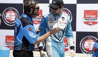 In this May 18, 2014 photo James Hinchcliffe, of Canada, talks with a crewman after his qualification run for the Indianapolis 500 IndyCar auto race at the Indianapolis Motor Speedway in Indianapolis. A week ago, there were questions that Hinchcliffe would be able to race in the Indianapolis 500 after suffering a concussion in the Grand Prix of Indianapolis. The 27-year old Canadian is not only cleared to drive, he&#39;s second on the grid for the most famous race in IndyCar (AP Photo/Tom Strattman)