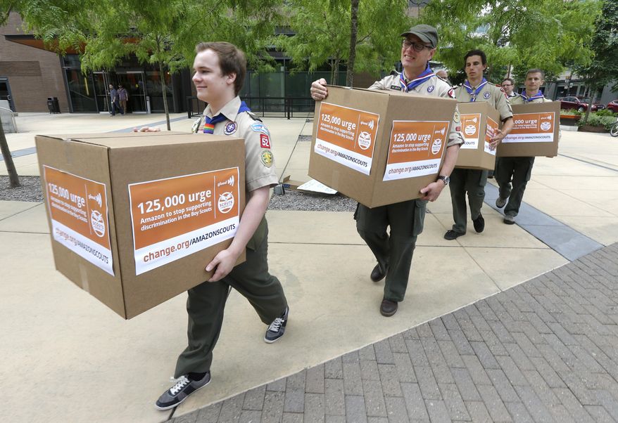 Pascal Tessier, 17, left, a gay Eagle Scout from Kensington, Md., leads a group of Boy Scouts and scout leaders, Wednesday, May 21, 2014, in delivering four boxes of signatures and comments on a petition to Amazon.com that was started as an online effort by Tessier, urging Amazon to stop donating money to the Boy Scouts due to the organization's policy of excluding openly gay adults from leadership positions, despite recently accepting gay youth as scouts, outside the headquarters of Amazon.com in Seattle. (AP Photo/Ted S. Warren)