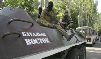 Pro-Russian gunmen atop of an armored personnel carrier with the words read &amp;quot;Battalion Vostok (East) &amp;quot; patrol a street in Donetsk, Ukraine, Tuesday, May 20, 2014. One rebel leader in Donetsk, Denis Pushilin, retaliated Tuesday by threatening to nationalize Akhmetov’s assets over his refusal to pay taxes to the Donetsk People’s Republic. (AP Photo/Alexander Ermochenko)