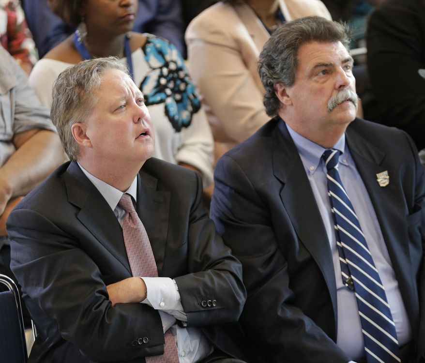 NASCAR CEO Brian France, left, and NASCAR president Mike Helton, right, watch a video after France&#x27;s grandmother, Anne Bledsoe France, was awarded the Landmark Award for the NASCAR Hall of Fame during an announcement in Charlotte, N.C., Wednesday, May 21, 2014. (AP Photo/Chuck Burton)