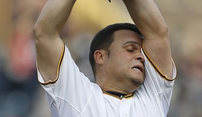 Pittsburgh Pirates starting pitcher Wandy Rodriguez (51) wipes his head as he throws against the Baltimore Orioles in the first inning of the baseball game on Wednesday, May 21, 2014, in Pittsburgh . (AP Photo/Keith Srakocic)