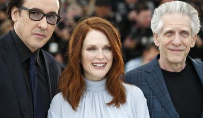 From left, actor John Cusack, actress Julianne Moore and director David Cronenberg pose for photographers during a photo call for Maps to the Stars at the 67th international film festival, Cannes, southern France, Monday, May 19, 2014. (AP Photo/Alastair Grant)