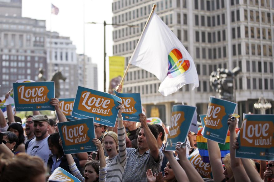 People hold up signs and cheer during a rally at City Hall, Tuesday, May 20, 2014, in Philadelphia. Pennsylvania's ban on gay marriage was overturned by a federal judge Tuesday. (AP Photo/Matt Slocum)