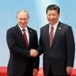 Russia&#39;s President Vladimir Putin, left, and China&#39;s President Xi Jinping shake hands before posing for a photo during the fourth Conference on Interaction and Confidence Building Measures in Asia (CICA) summit, in Shanghai, China, Wednesday, May 21, 2014.  (AP Photo/RIA Novosti, Mikhail Metzel, Presidential Press Service)