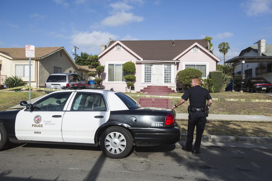 A police officer stands guard in front of the home of actor Michael Jace on Tuesday, May 20, 2014, in Los Angeles. Jace, who played a police officer on the hit TV show "The Shield," was arrested on suspicion of homicide after his wife was found shot to death in their Los Angeles home, authorities said. Police arrived at the couple's home around 8:30 p.m. Monday after a report of shots fired, Officer Chris No said. April Jace, 40, was found dead inside, officials said. Jace was taken into custody and booked early Tuesday on suspicion of homicide, No said. He was being held in a Los Angeles jail in lieu of $1 million bail. (AP Photo/Ringo H.W. Chiu)