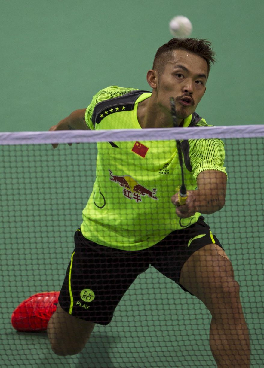 In this Tuesday, May 20, 2014 photograph, China’s Lin Dan returns a shot to Taiwan's Lin Yu Hsien during their men's singles event of the Thomas Cup Badminton in New Delhi, India. Lin Dan completed the score-line with a hard-fought 19-21, 21-13, 21-14 win. (AP Photo/Tsering Topgyal)