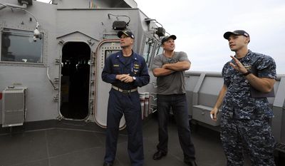 This May 20, 2014 photo released by TNT shows actor Adam Baldwin from the new TNT series "The Last Ship," center, getting a tour of the bridge deck from Cmdr. Scott Bowman of the USS Oak Hill en route to New York Harbor for Fleet Week celebrations. On Tuesday, Baldwin hosted a special screening of the series aboard the dock landing ship. The series, also starring Eric Dane and Rhona Mitra, premieres on Sunday, June 22, at 9 p.m. ET. (AP Photo/TNT, E. M. Pio Roda)