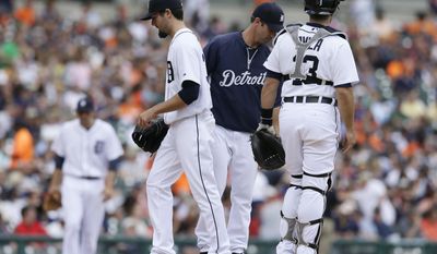 Detroit Tigers starting pitcher Robbie Ray, left foreground, is relieved by manager Brad Ausmu, center, as catcher Alex Avila looks on, during the fourth inning of a baseball game against the Texas Rangers  in Detroit, Thursday, May 22, 2014. (AP Photo/Carlos Osorio)