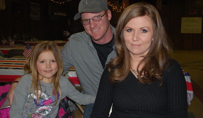 In this photo taken March 21, 2014, Wyoming Army National Guard member Thomas Watts, 29, spoke during dinner at the Powell American Legion post in Powell, Wyo. His wife Jessy, right, and their daughter Hayden pose with him for a photo. Watts, , who served nine months in Bahrain with the Wyoming Army National Guard, was the speaker for the event. The American Legion was founded by World War I veterans in France and chartered by Congress in 1919, but as its centennial approaches, the American Legion&#x27;s future is uncertain. (AP Photo/The Powell Tribune, Tom Lawrence)