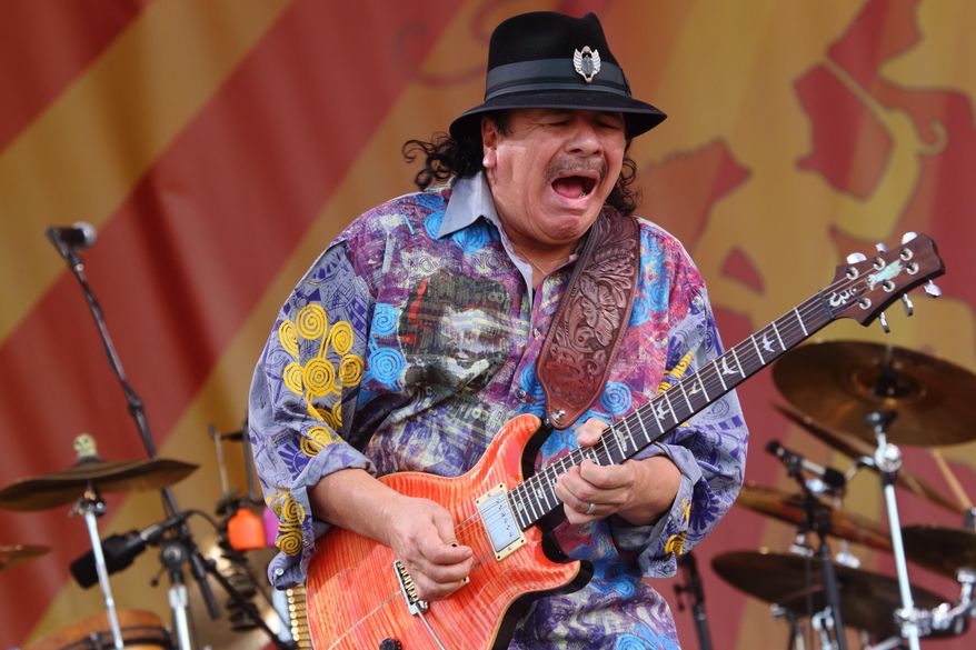 FILE - This April 25, 2014 file photo shows Carlos Santana performing at the 2014 New Orleans Jazz & Heritage Festival in New Orleans. Santana’s latest album, “Corazon,” debuted at No. 9 on the Billboard 200 albums chart last week. It features Juanes, Gloria Estefan and Miguel, and Santana said it wasn’t hard finding “Cinderella or Cinderfella” to guest on the songs, which he calls “glass slippers.” (Photo by John Davisson/Invision/AP, File)