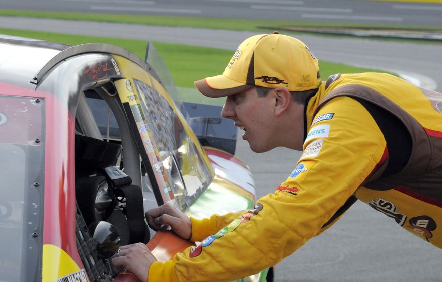 Kyle Busch looks into his car before qualifying for Sunday&#39;s NASCAR Sprint Cup series auto race at Charlotte Motor Speedway in Concord, N.C., Thursday, May 22, 2014. (AP Photo/Mike McCarn)