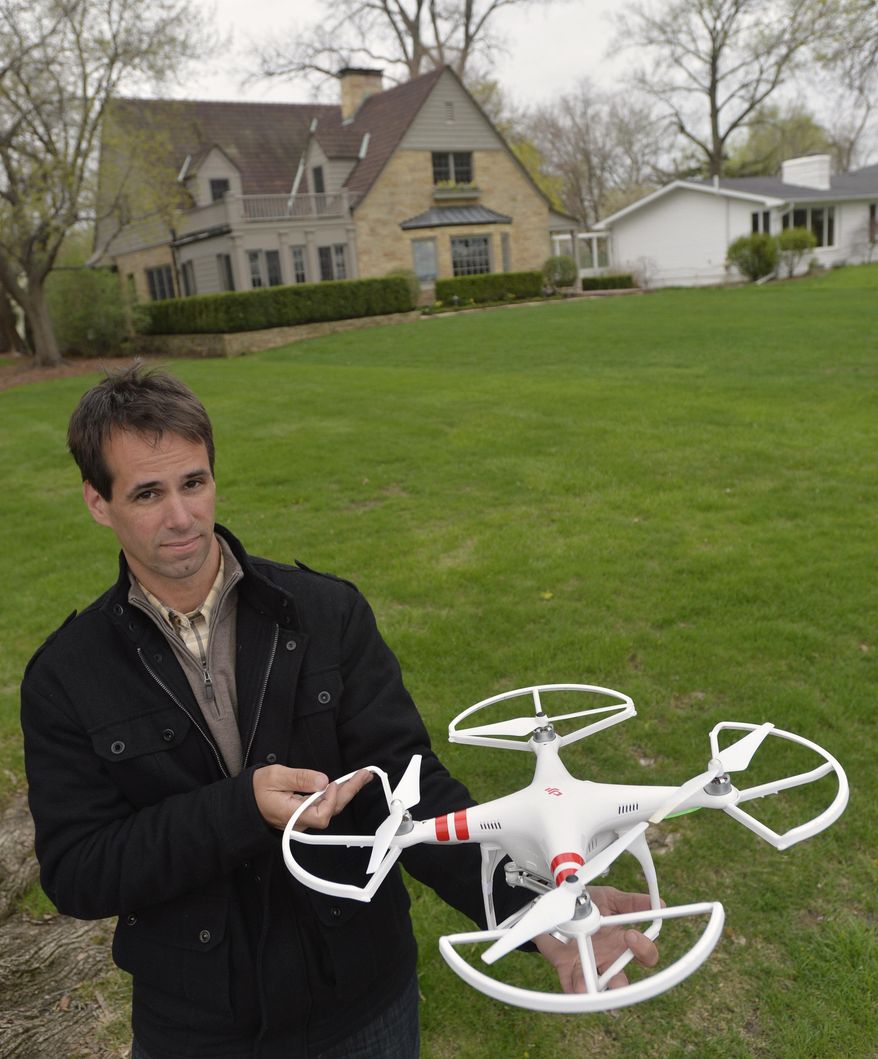 ADVANCE FOR USE SUNDAY, MAY 25 AND THEREAFTER - In this April 29, 2014 photo, Mark Monge holds a drone he uses to photograph homes for his work as a realtor for Jim Maloof Realty in Peoria, Ill. Monge, who sells homes with wife Jennifer, recently acquired the DJI Phantom II model. He’s already used the device to photograph many area homes. (AP Photo/Journal Star, Ron Johnson)